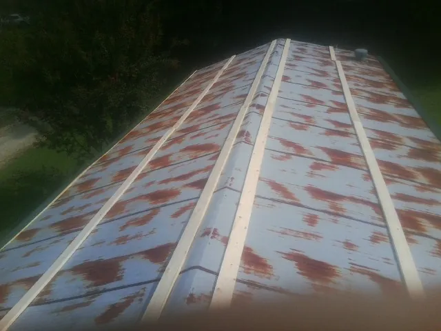 Rusted metal roof panels with new wood purlins before replacement — Storm Damage Roof Repair in Biscoe by Roofing Brothers