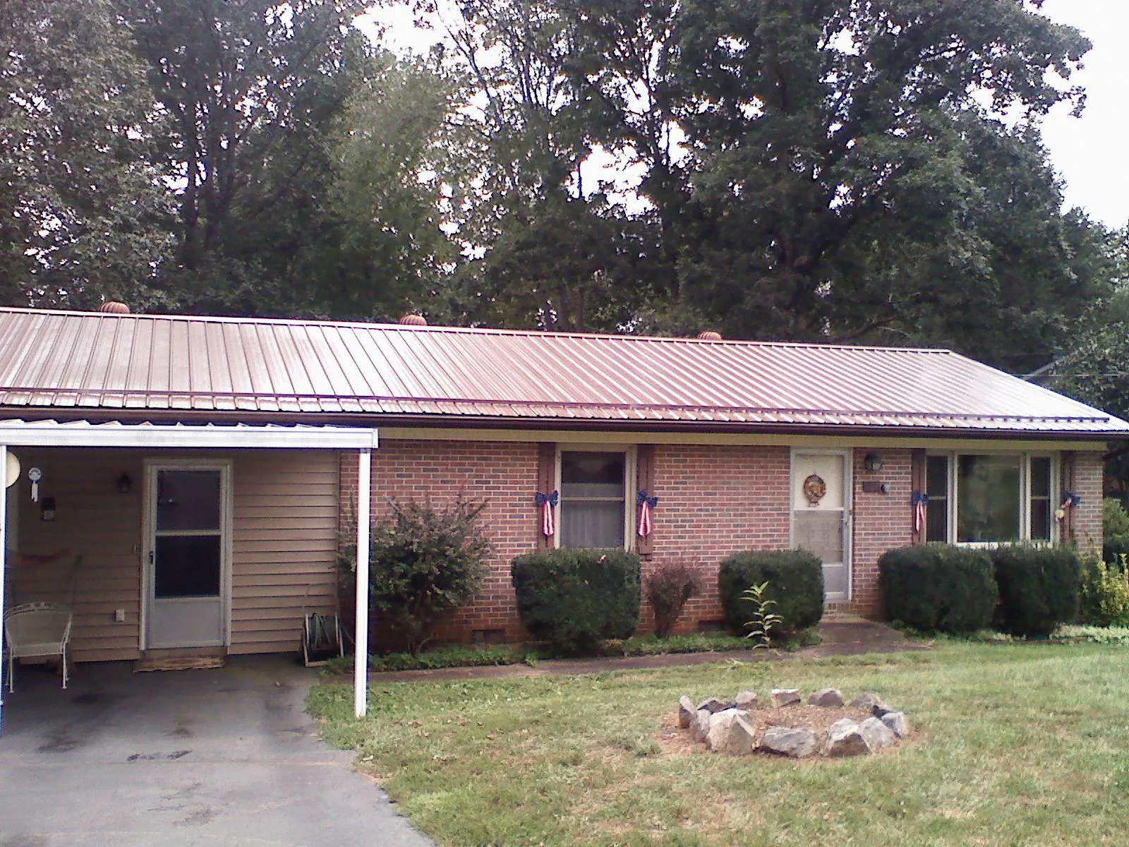 Bronze metal roof and carport on a brick ranch home — Roof Repair work by our crew in Biscoe